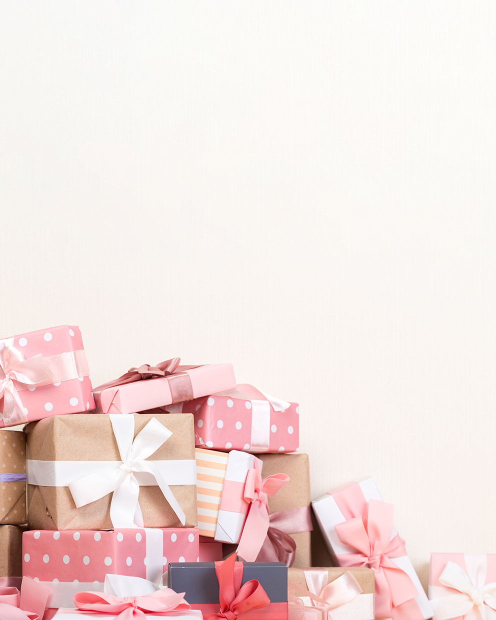gift boxes on a wooden table. colorfully wrapped gifts with pink ribbons. Holiday Greeting Card.