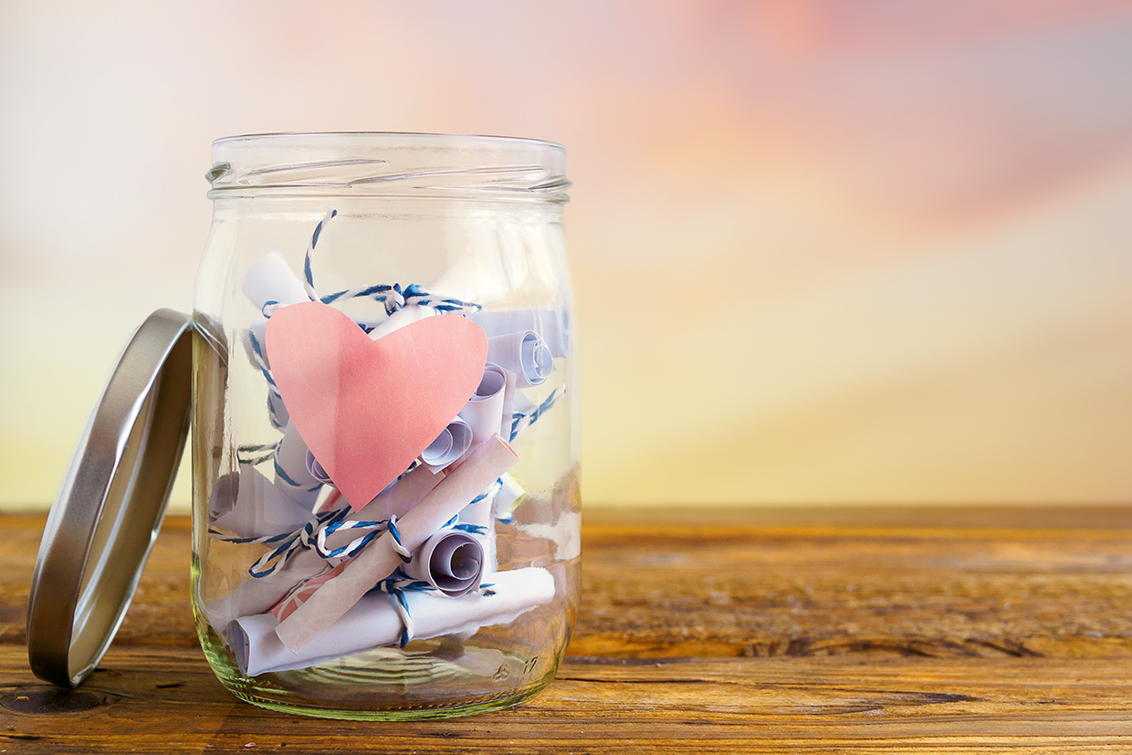 Jar with pink heart and rolled-up notepads