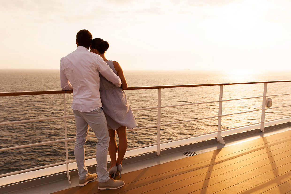 young couple hugging at sunset on cruise ship